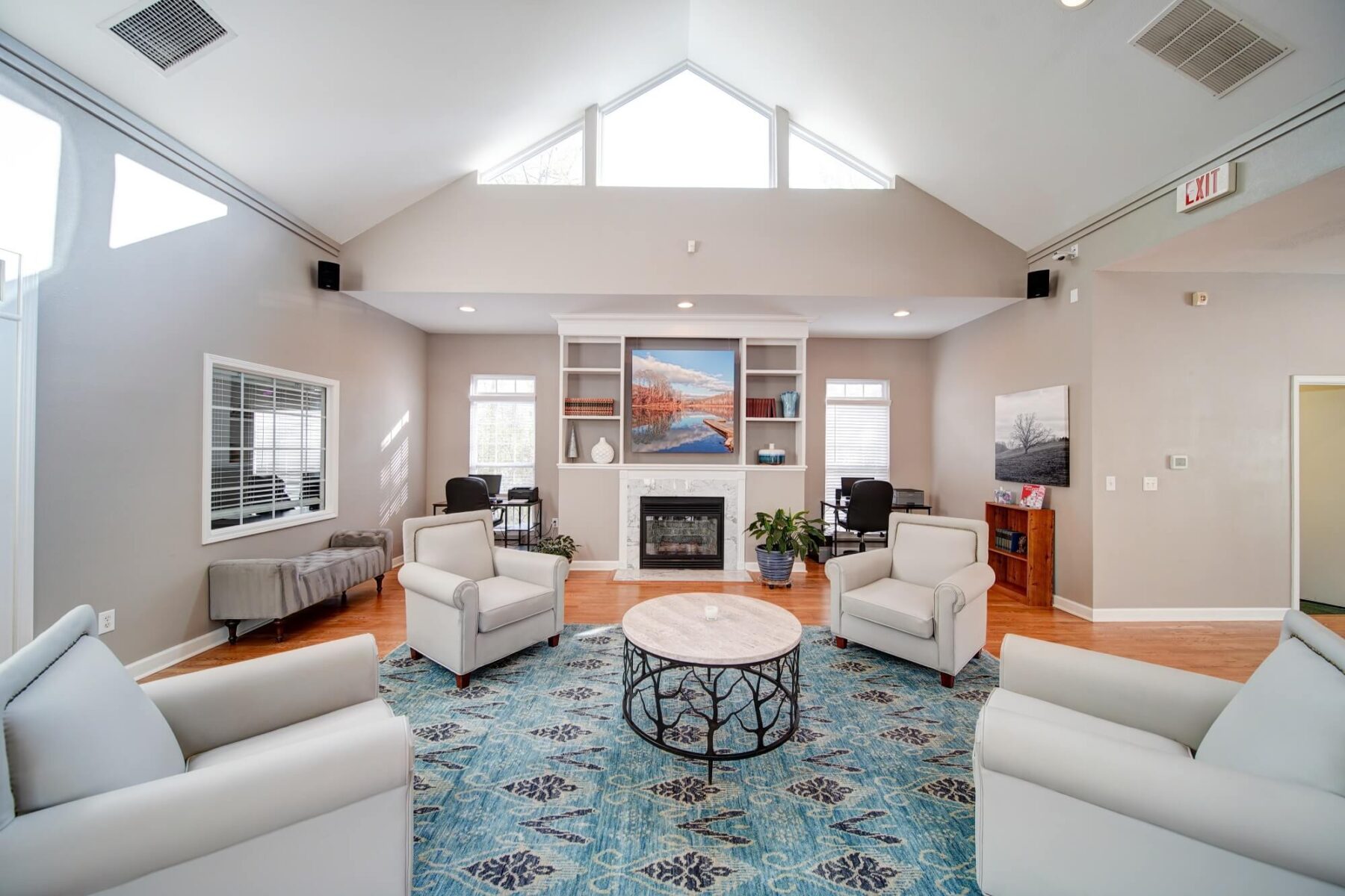 Clubhouse space with armchair seating, fireplace and two computer desks