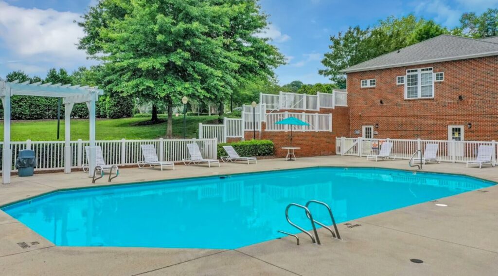 Pool with patio space and lounge chairs.