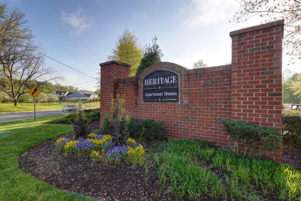Brick signage by the road for Heritage Apartments in 27278.