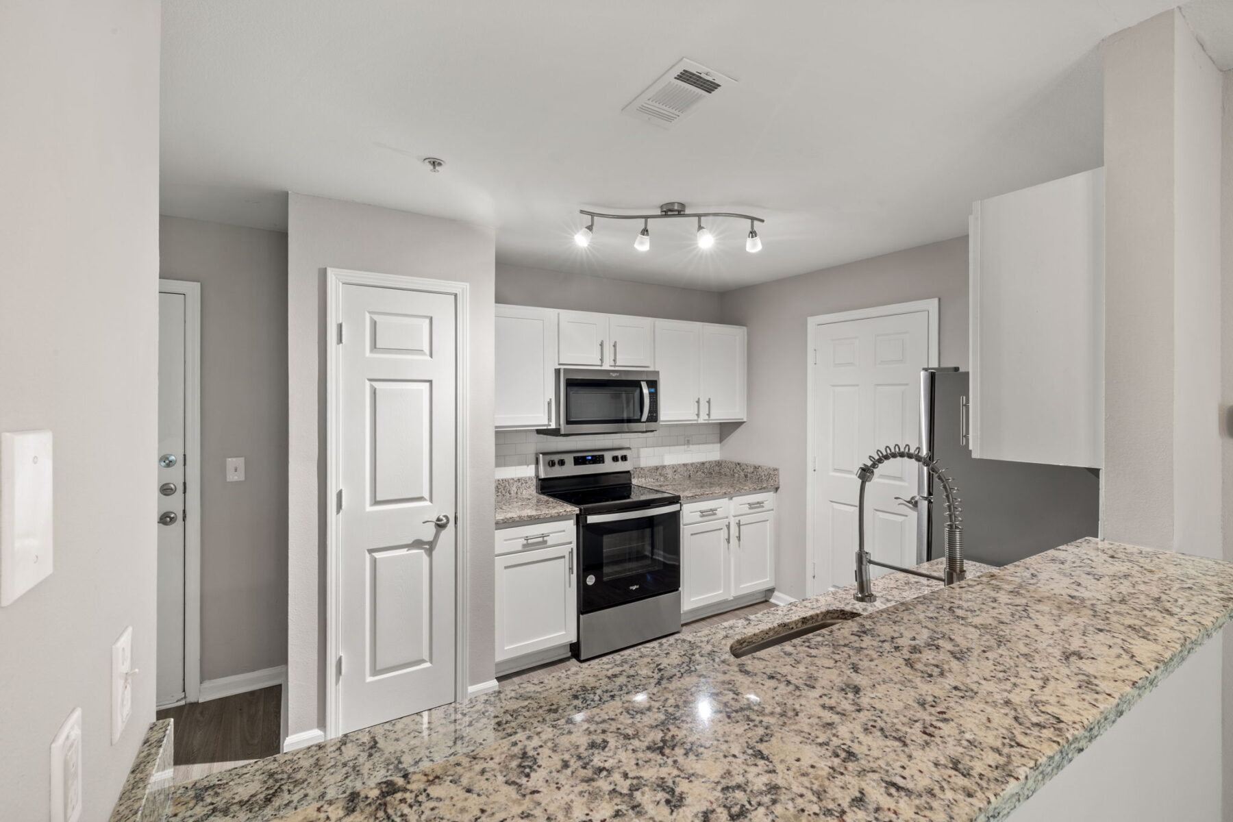 Wrap around kitchen with granite countertops and appliances in a 1 bedroom apartment in Hillsborough, NC at Heritage Apartments.